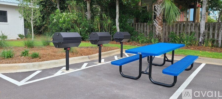 A blue picnic table is in the middle of a parking lot.