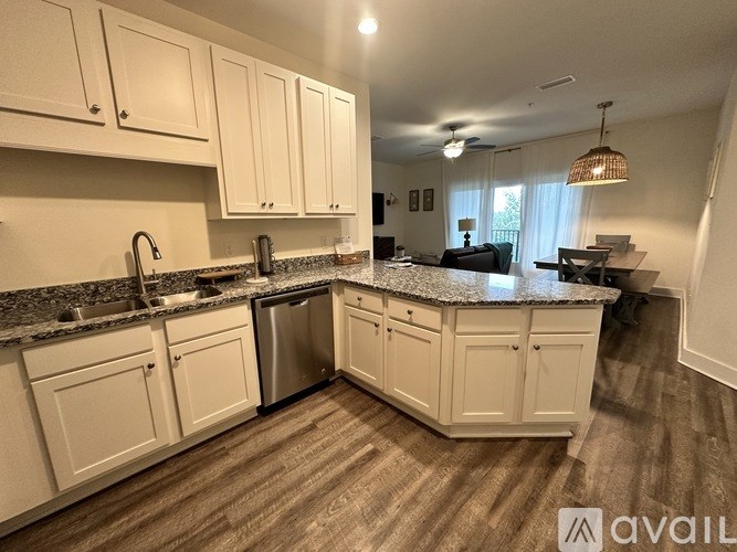 A kitchen with white cabinets and a granite countertop.