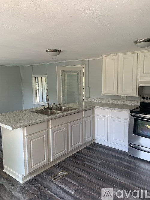 A kitchen with a marble countertop and white cabinets.