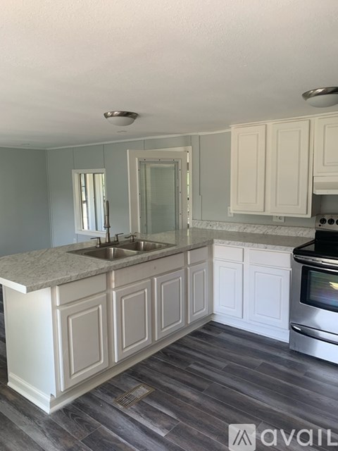 A kitchen with a marble countertop and white cabinets.