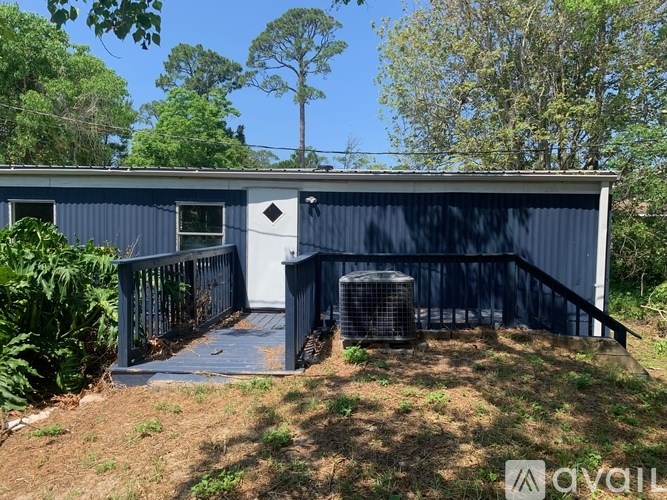 A blue building with a white door and a balcony.