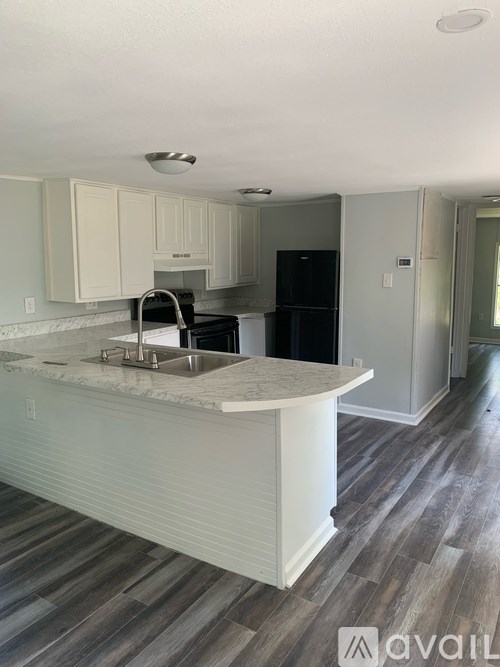 A kitchen with a white countertop and a sink.