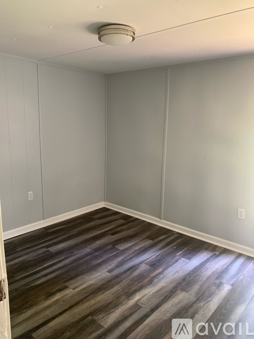 A room with wooden flooring and white walls.