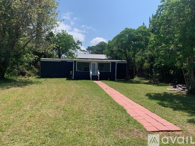 A house with a red pathway leading to it.