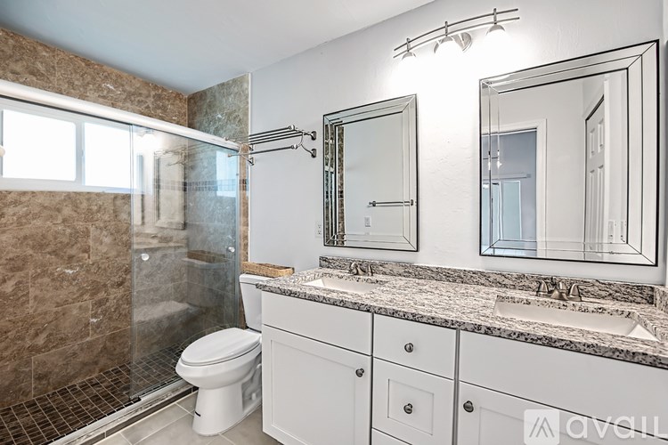 A bathroom with a marble countertop and a walk-in shower.