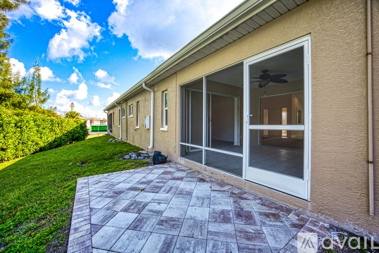A sunny day at a house with a patio and a fan.