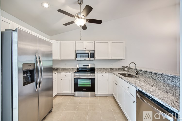 A modern kitchen with a stainless steel refrigerator and white cabinets.