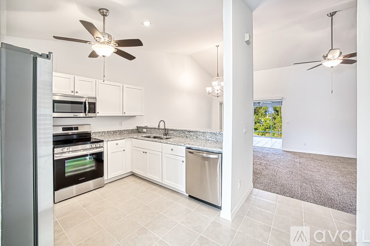 A kitchen with white cabinets and a tile floor.