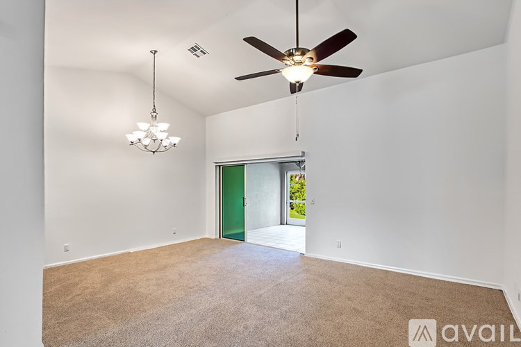 A room with a ceiling fan and a chandelier.