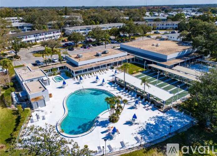 An aerial view of a swimming pool area with a building in the background.