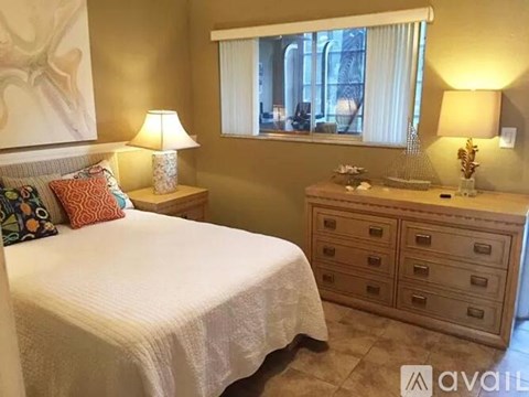A bedroom with a large bed and a dresser with a mirror.