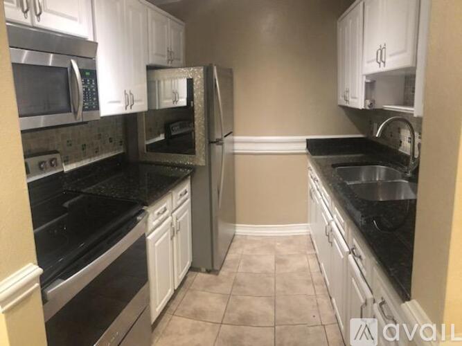A kitchen with black countertops and white cabinets.