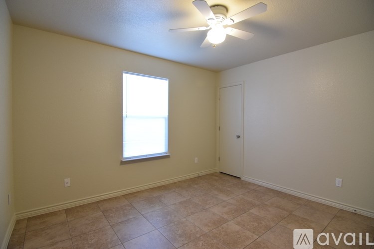 A room with a ceiling fan and a window.