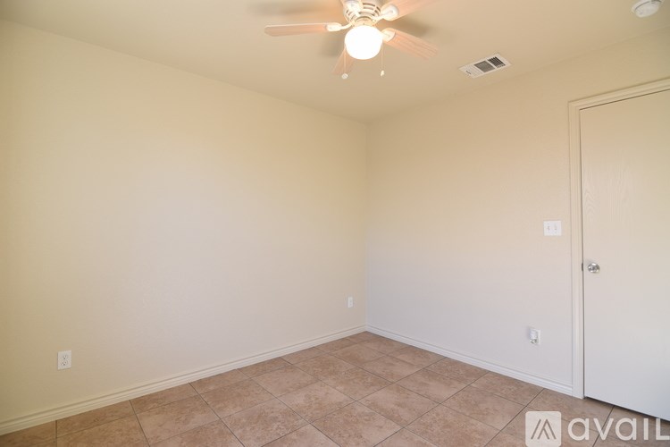 A room with a ceiling fan and tile flooring.