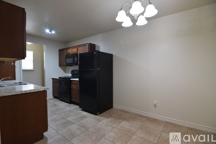 A kitchen with black appliances and brown cabinets.