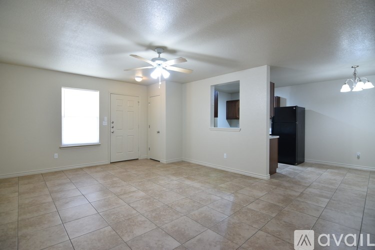 A spacious room with a ceiling fan and tiled flooring.