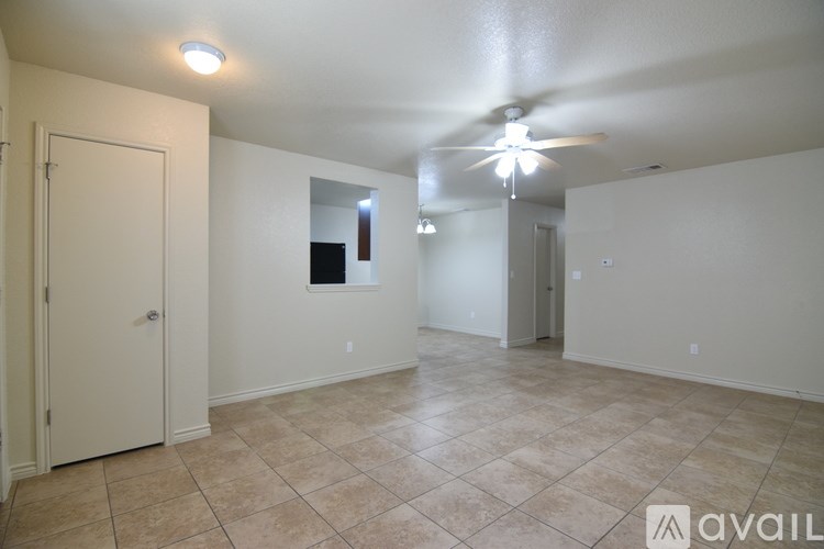 A spacious room with a ceiling fan and tiled flooring.