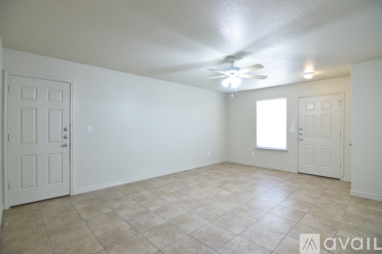 A room with a ceiling fan and tile flooring.