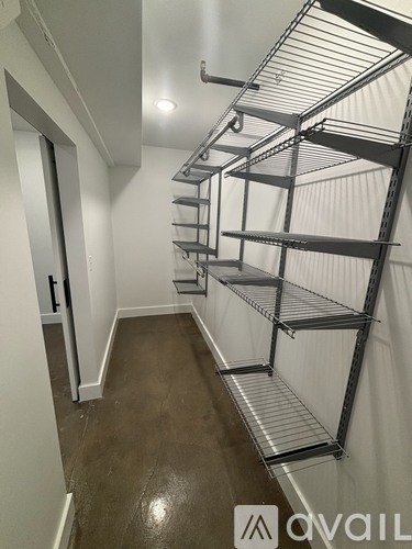 A long metal shelving unit in a room with white walls.