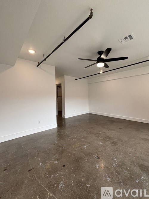 A room with a ceiling fan and a door.