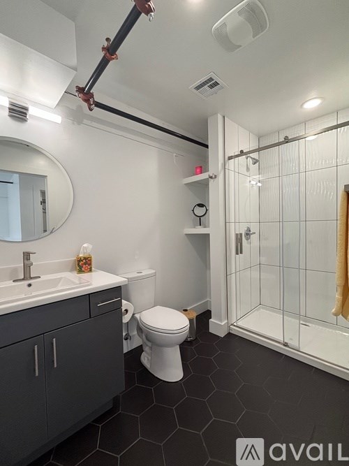 A bathroom with a toilet, sink, and shower.