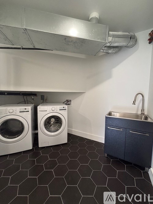 A laundry room with a washer and dryer and a sink.