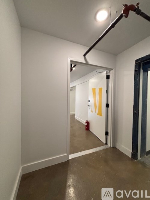 A hallway with a white door and a red fire extinguisher.