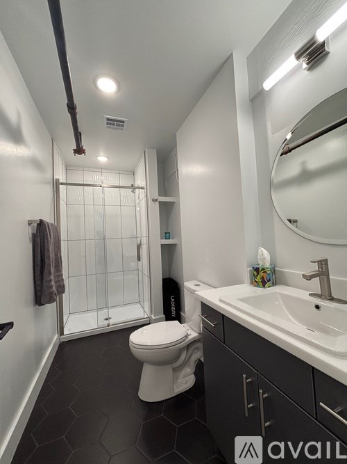 A bathroom with a toilet, sink, and mirror.