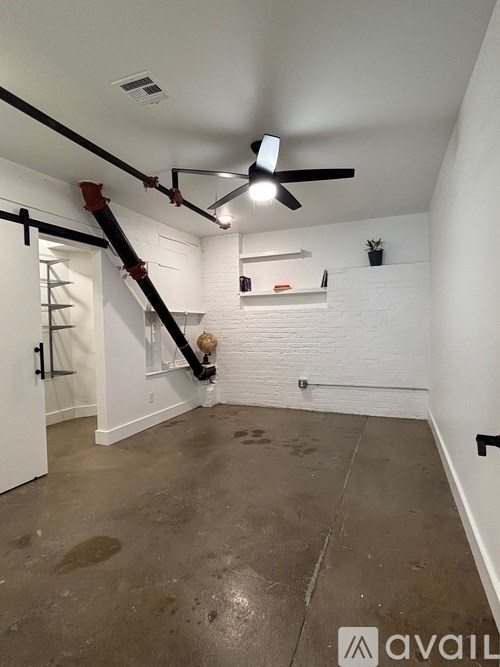 A room with a ceiling fan and a ladder.