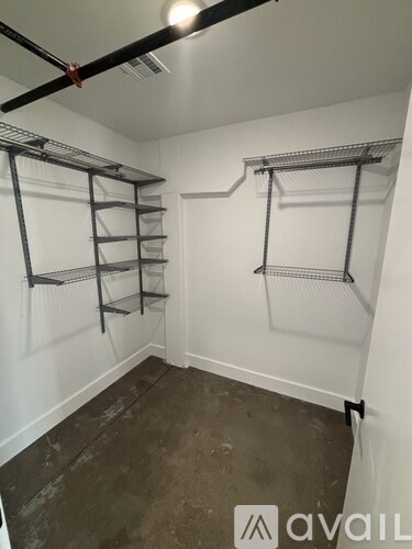 A room with a white wall and a metal shelf.