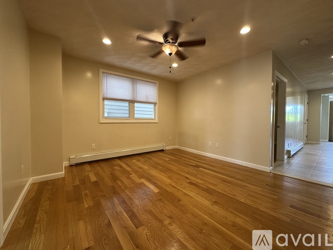 A room with wooden flooring and a ceiling fan.