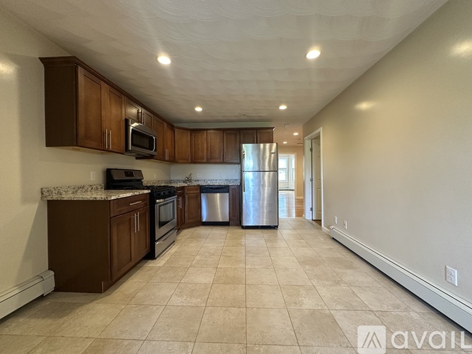 A kitchen with brown cabinets and a stainless steel dishwasher.