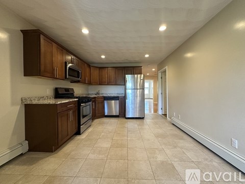 A kitchen with brown cabinets and a stainless steel dishwasher.