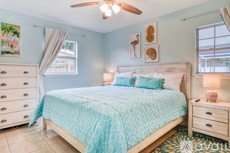 A bedroom with a bed, dresser, and nightstand.