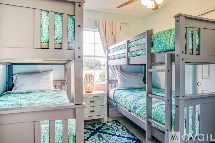 A bedroom with two bunk beds and a ceiling fan.