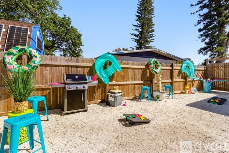 A backyard with a blue chair and a grill.