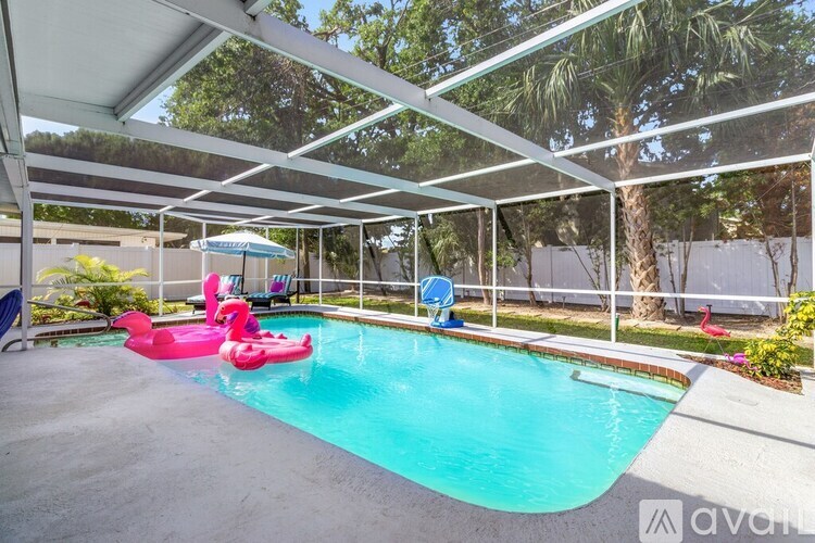 A pool with a pink flamingo float and a blue float.