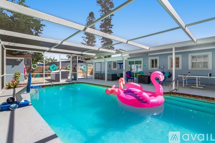 A pool with a pink flamingo float in it.