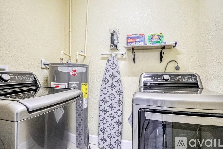 A tie is hanging on a wall next to a washing machine.