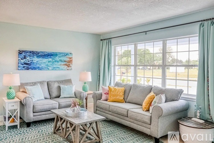 A living room with two couches, a coffee table, and a painting on the wall.