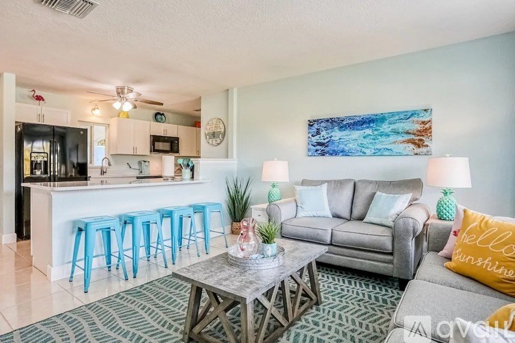 A living room with a grey couch, a coffee table, and a painting on the wall.
