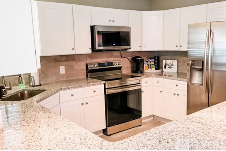 A kitchen with white cabinets and a granite countertop.
