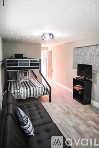 A black leather sofa with a striped pillow in a living room.