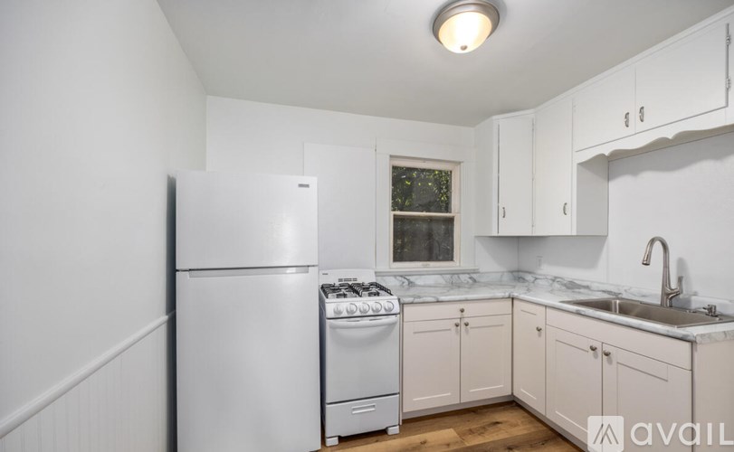 A kitchen with white appliances and cabinets.