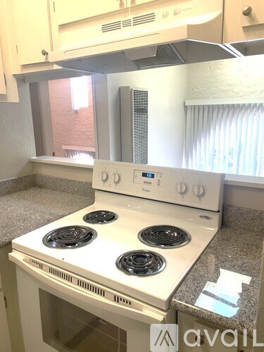 A white stove top oven with four burners and a control panel on the front.