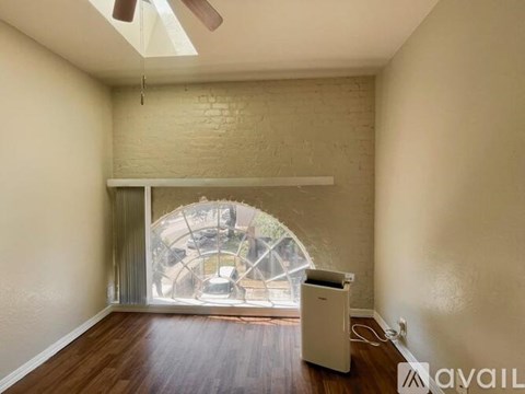 A room with a window showing a view of a street with cars and buildings.