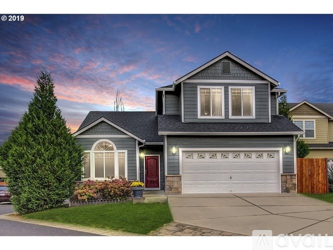 A house with a grey roof and a red door is shown.