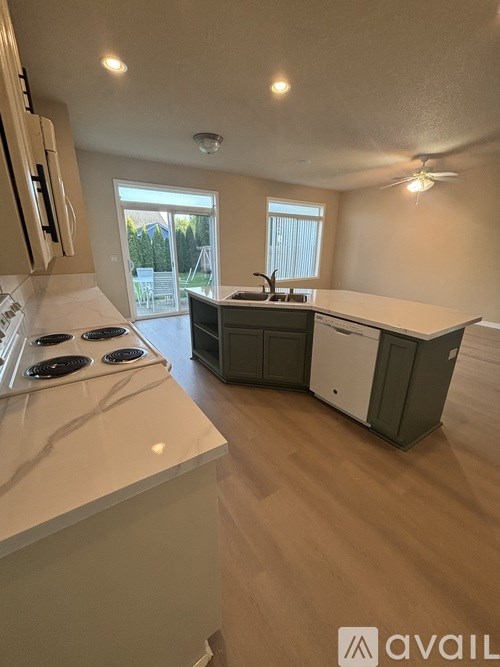 A kitchen with white countertops and a stove top oven.