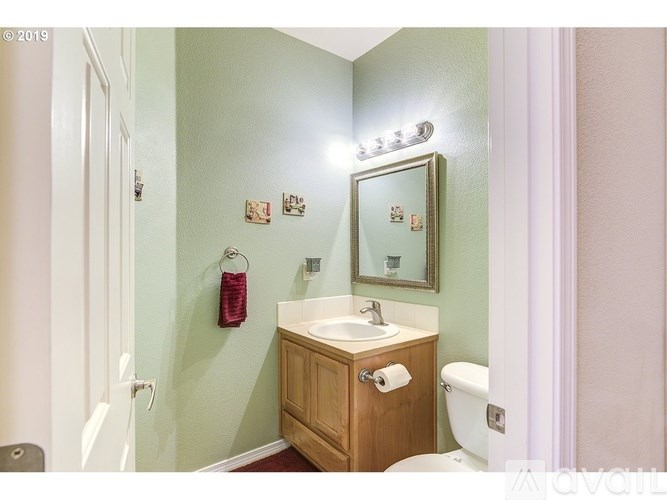 A bathroom with a sink, mirror, and toilet.
