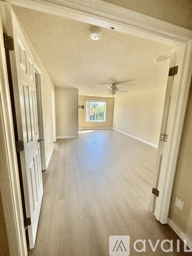A long hallway with a fan and a window.